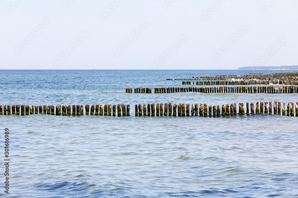 At the shore there are rows of thick wooden poles