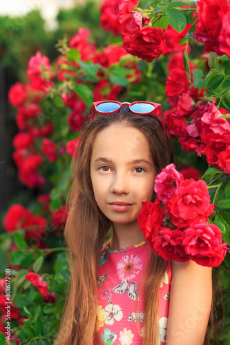 Portrait of cute teen girl smiling at the roses