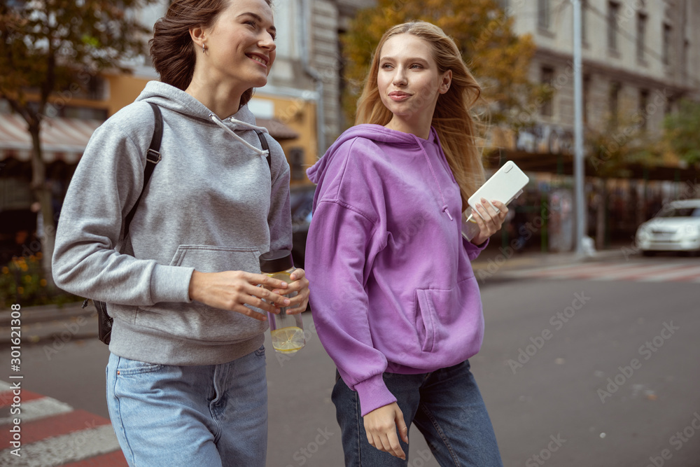 Positive delighted young females having pleasant conversation