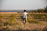 Summer, dry grass, a man in shorts runs through the meadow. A quiet field, followed by blue water, so close the sea.