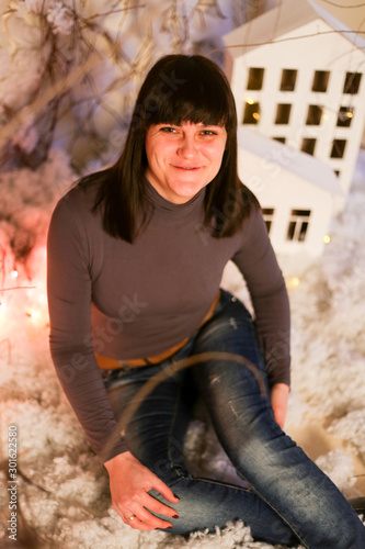 woman in Christmas decorations with artificial snow and small cardboard houses
