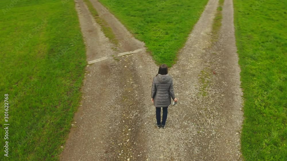 Woman at the crossroads. Symbol of choice.  Aerial shot from the coptere.4K