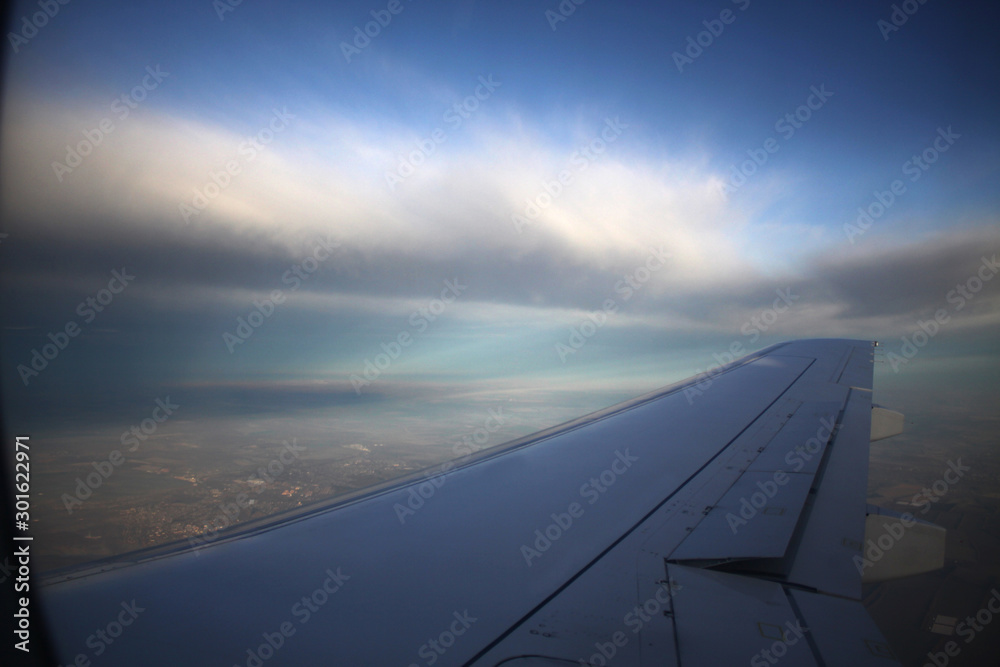 Wing of an airplane flying above the clouds. Travelling concept Wing of an airplane flying above the clouds. Travelling concept