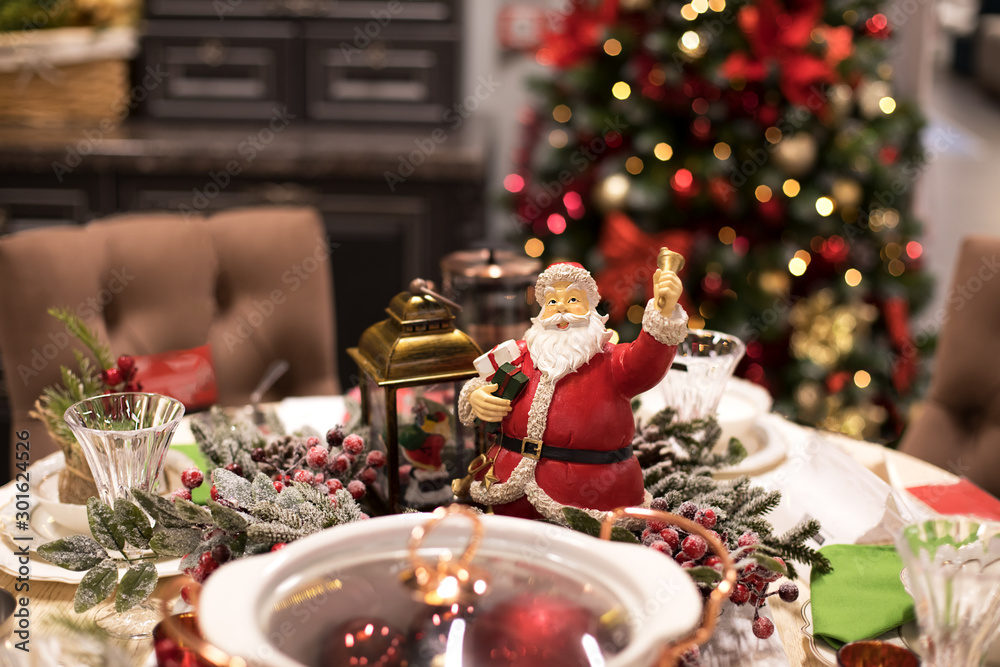 Christmas table seting with Santa and christmas tree behind