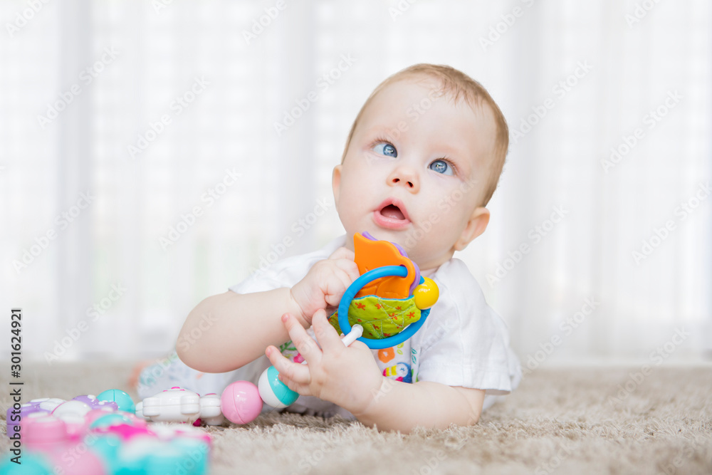 Cute baby girl holding a toy on the carpet Cute baby girl holding a toy on the carpet