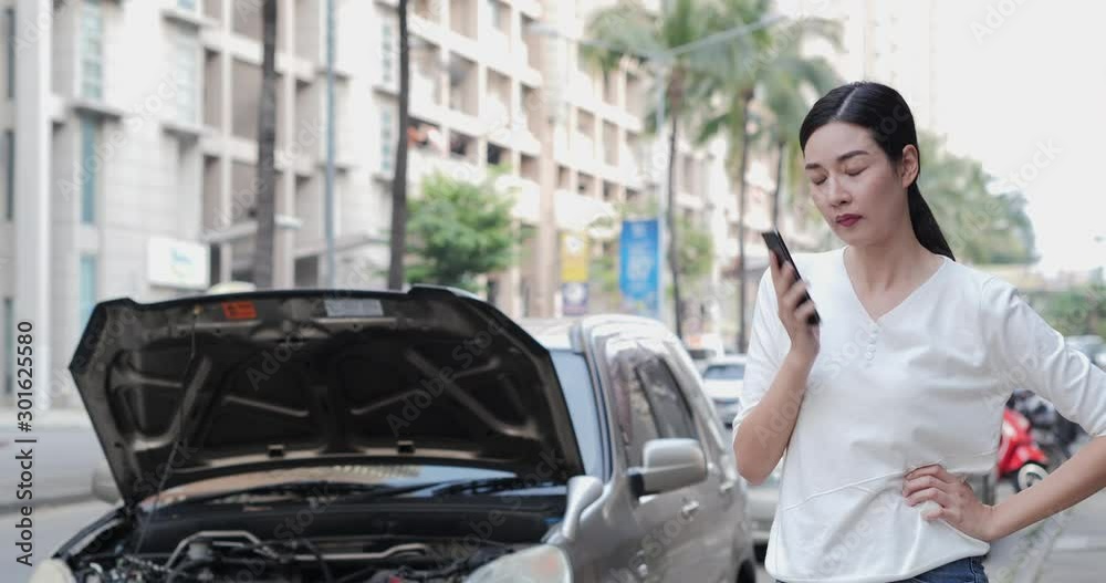 Asian woman using phone to talk with insurance with serious emotion. Her having problem at the road. Asian woman using phone to talk with insurance with serious emotion. Her having problem at the road.