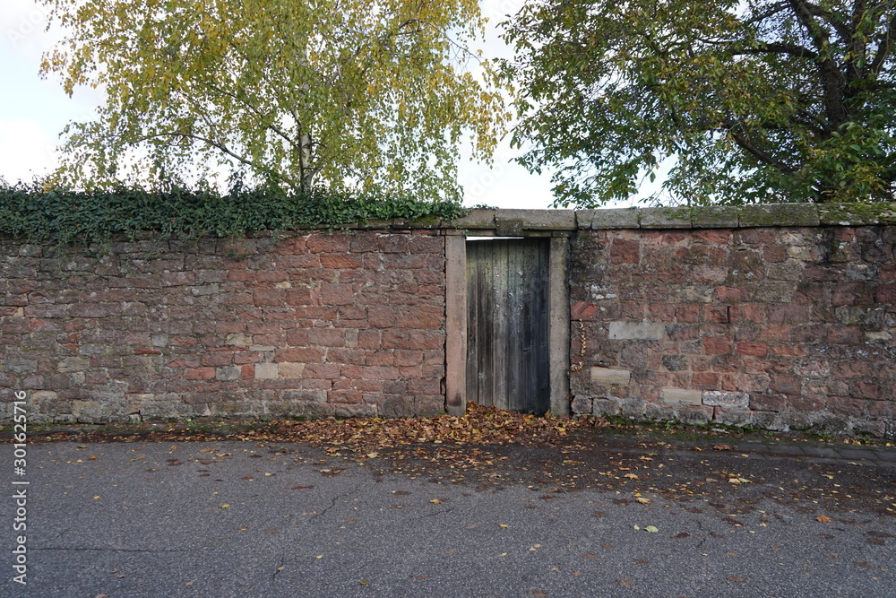 Holztür in einer historischen Mauer mit Schlussstein