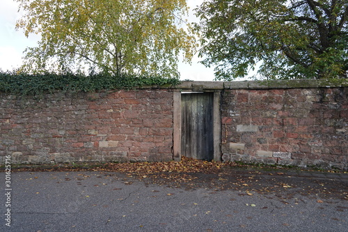 Holztür in einer historischen Mauer mit Schlussstein