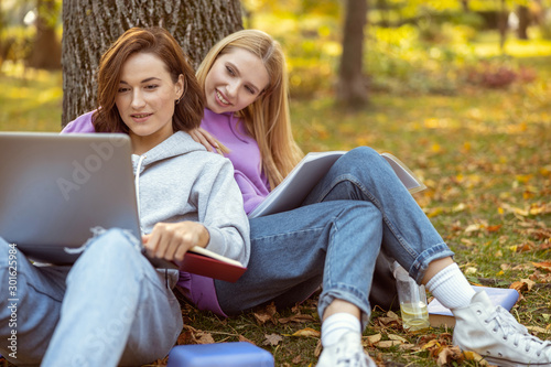 Joyful young females preparing for test paper