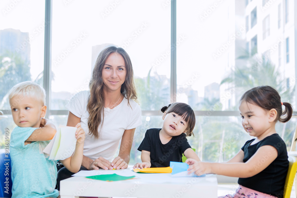 Nursery teacher and her students make paper crafts Nursery teacher and her students make paper crafts