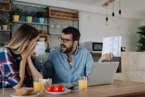 Young couple arguing while having problems with their home finances