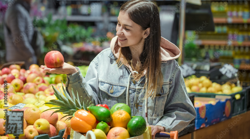 A young woman buys groceries in a supermarket. A young woman buys groceries in a supermarket.