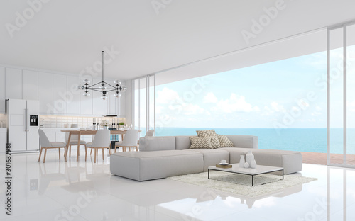 Luxury white living dining room with sea view 3d render.There is a minimalistic building interior with white fabric furniture. There is a large open sliding door overlooking the sea view.