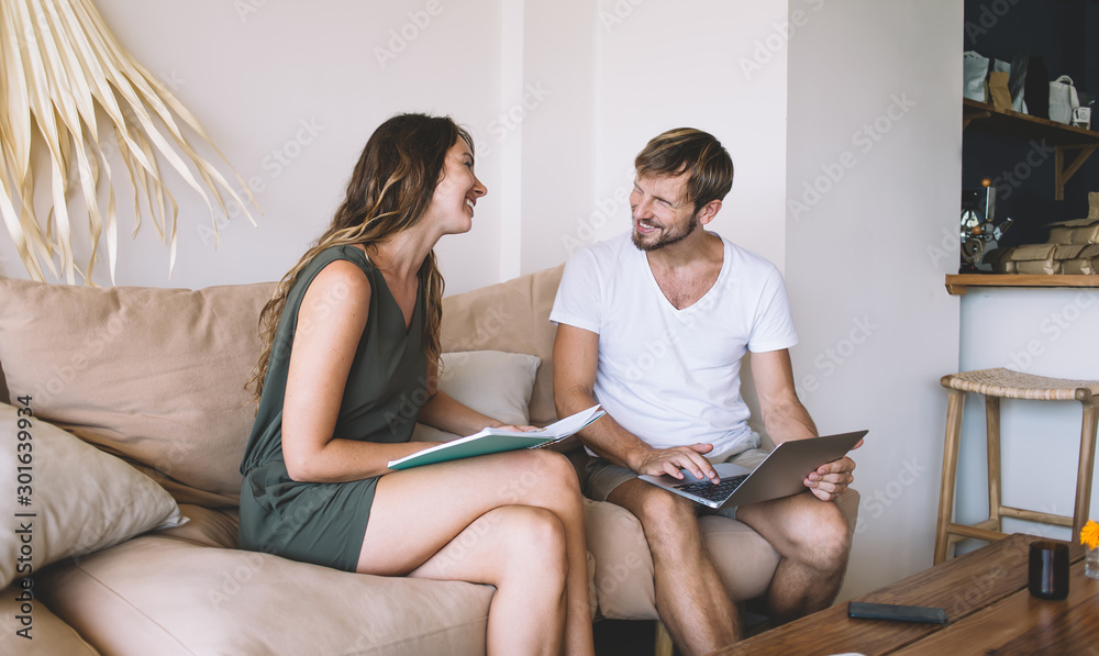 Smiling couple working on couch