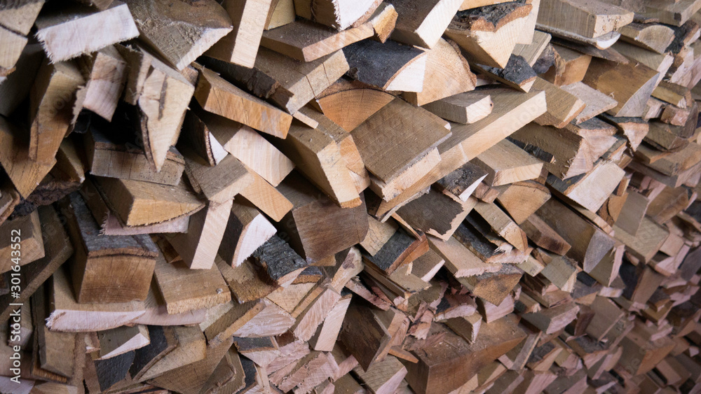 Background of dry chopped firewood logs in a pile. Harvesting firewood for the winter. Background of dry chopped firewood logs in a pile. Harvesting firewood for the winter.