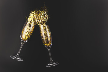 Creative shot of two champagne glasses and confetti. Christmas, New Year celebration concept.
