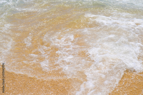 Wave on wet beach sand. The clear water and sand on the Mediterranean Sea on Costa Brava, Spain.
