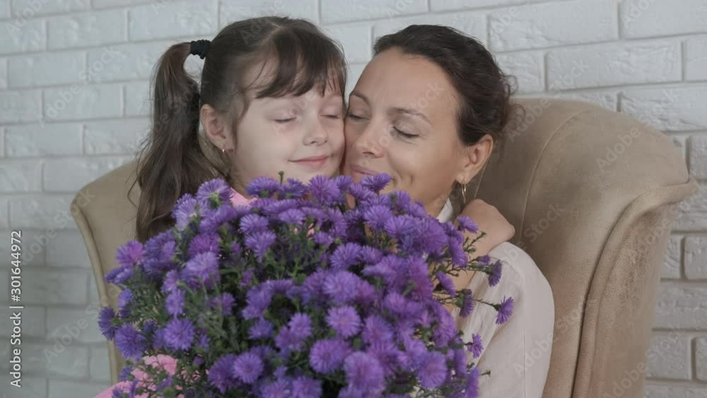 Flowers for mom. Woman with a child with a bouquet of blue flowers. Flowers for mom. Woman with a child with a bouquet of blue flowers.