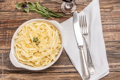 Wall Mural Homemade fettuccine with bechamel sauce in a white plate, rustic wooden table ba