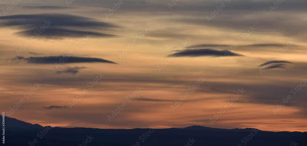 splendid autumn sunset with different types and colors of lenticular clouds