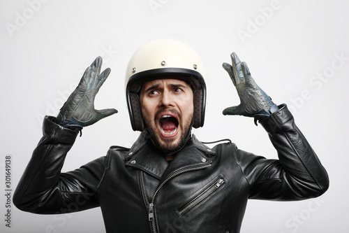 Close-up portrait of biker with hands up wearing white helmet. Isolated.
