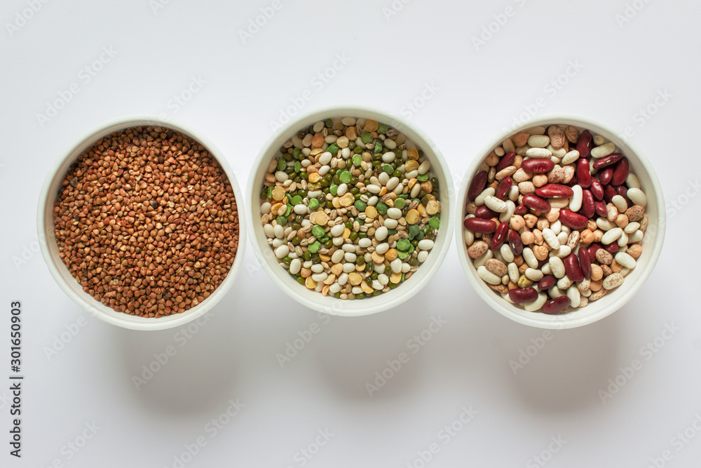 Three bows with variety of legume grains buckwheat, white red beans on white background. Three bows with variety of legume grains buckwheat, white red beans on white background.