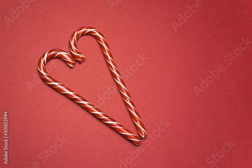 Candy Cane with hearts on a red background. Candy Cane Day Poster, December 26. Sweet Christmas symbol. New year and Christmas card