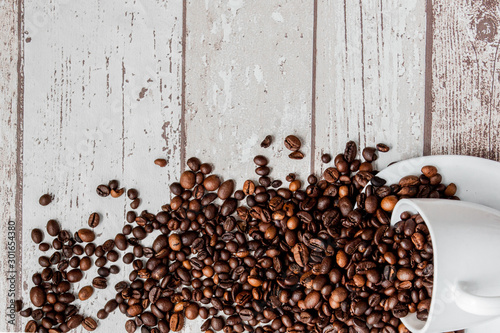 Black coffee in white cup and coffee beans on light wooden background. Top view  space for text