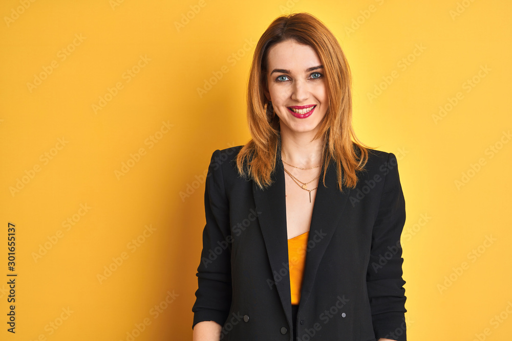 Redhead caucasian business woman over yellow isolated background with a happy and cool smile on face. Lucky person. Redhead caucasian business woman over yellow isolated background with a happy and cool smile on face. Lucky person.