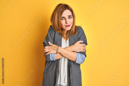 Redhead caucasian business woman over yellow isolated background worried and stressed about a problem with hand on forehead, nervous and anxious for crisis © Krakenimages.com