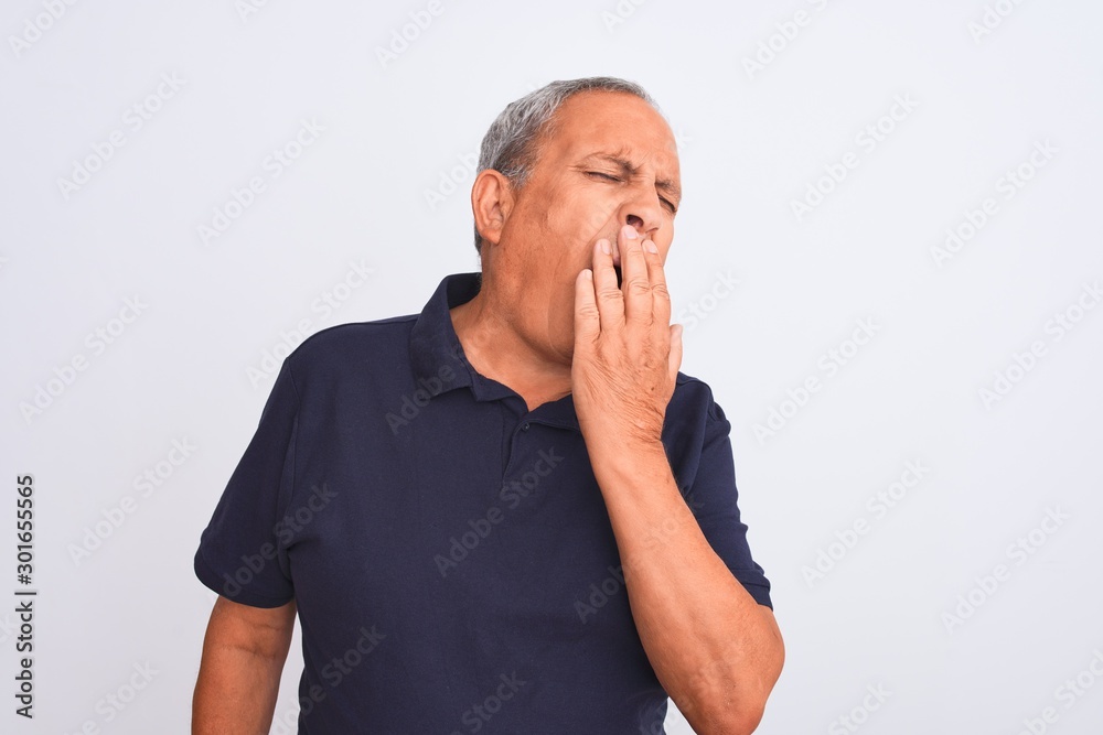 Senior grey-haired man wearing black casual polo standing over isolated white background bored yawning tired covering mouth with hand. Restless and sleepiness. Senior grey-haired man wearing black casual polo standing over isolated white background bored yawning tired covering mouth with hand. Restless and sleepiness.