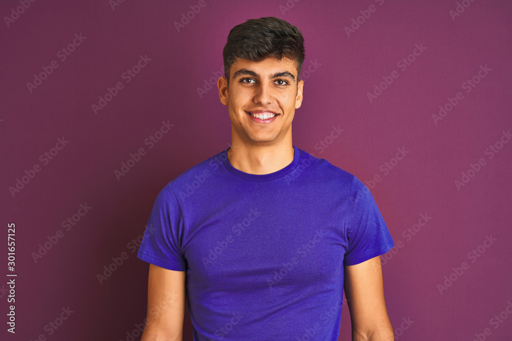 Young indian man wearing t-shirt standing over isolated purple background with a happy and cool smile on face. Lucky person. Young indian man wearing t-shirt standing over isolated purple background with a happy and cool smile on face. Lucky person.