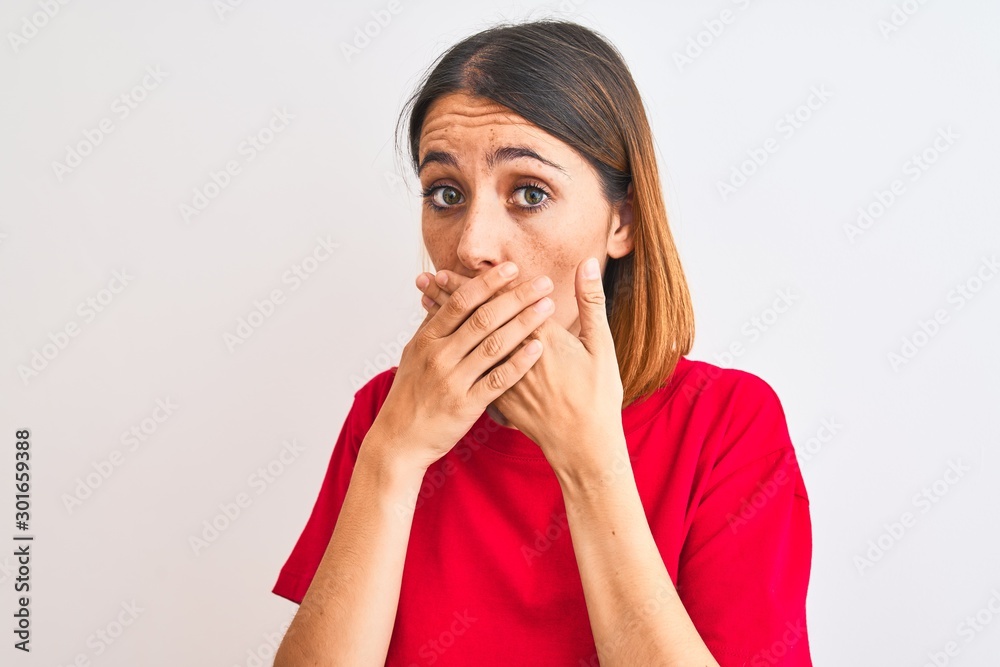 Beautiful redhead woman wearing casual red t-shirt over isolated background shocked covering mouth with hands for mistake. Secret concept. Beautiful redhead woman wearing casual red t-shirt over isolated background shocked covering mouth with hands for mistake. Secret concept.