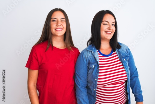 Young beautiful women wearing casual clothes standing over isolated white background winking looking at the camera with sexy expression, cheerful and happy face.