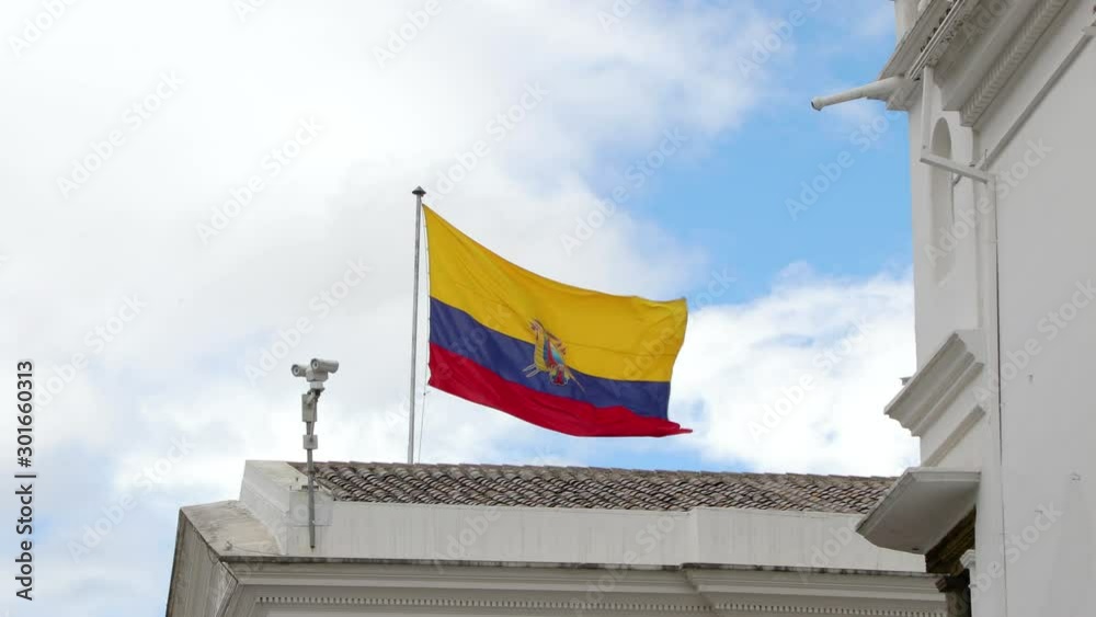 Ecuador flag waving on top of an urban building