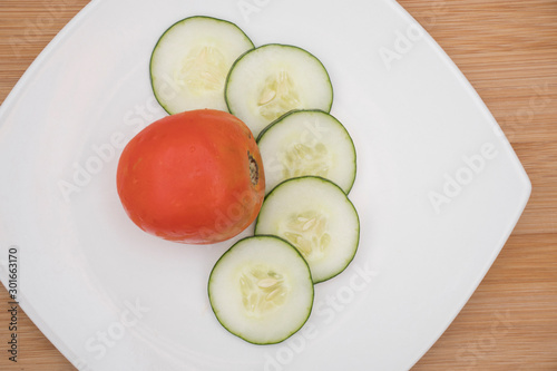 tomate y pepino en rodajas sobre plato blanco