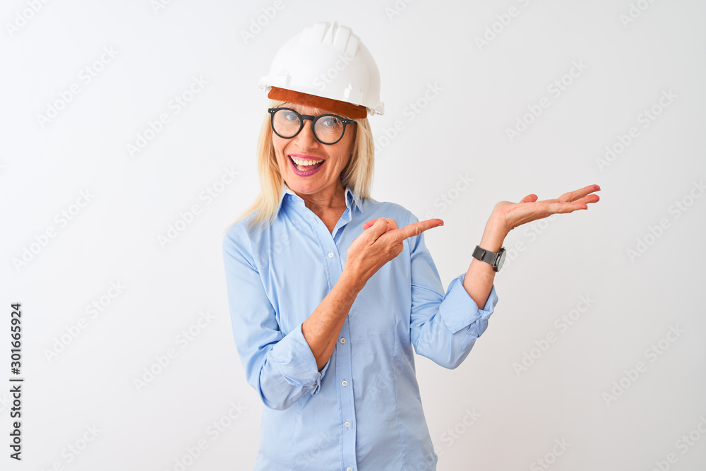 Middle age architect woman wearing glasses and helmet over isolated white background amazed and smiling to the camera while presenting with hand and pointing with finger. Middle age architect woman wearing glasses and helmet over isolated white background amazed and smiling to the camera while presenting with hand and pointing with finger.