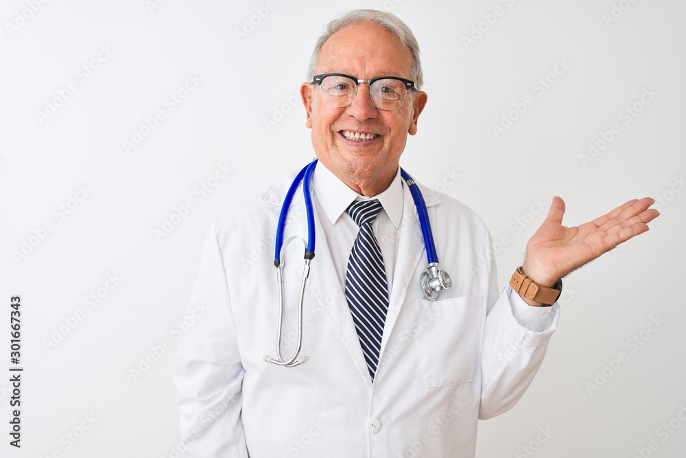 Senior grey-haired doctor man wearing stethoscope standing over isolated white background smiling cheerful presenting and pointing with palm of hand looking at the camera. Senior grey-haired doctor man wearing stethoscope standing over isolated white background smiling cheerful presenting and pointing with palm of hand looking at the camera.