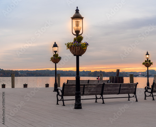 Street Lights on a Dock with Benches Overlooking a River and Colorful Sky