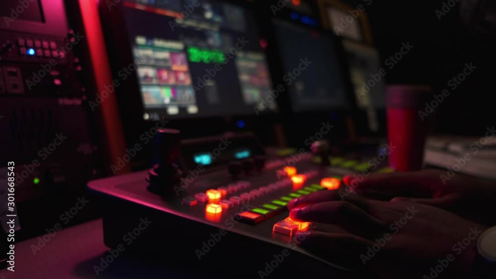 Black man directing a live church service in dark broadcast room with red lighting