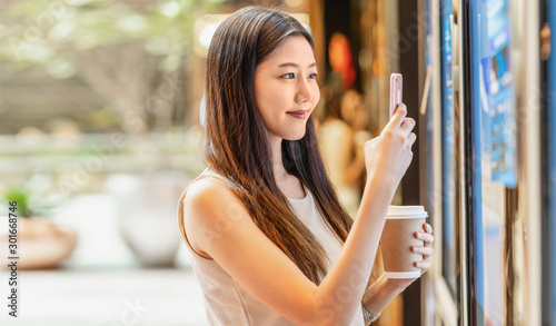 Quadro em tela Asian young woman hand using smart mobile phone scanning the movie tickets machi