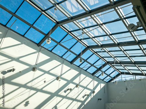 view from below the transparent glass roof of shopping mall at sunny day
