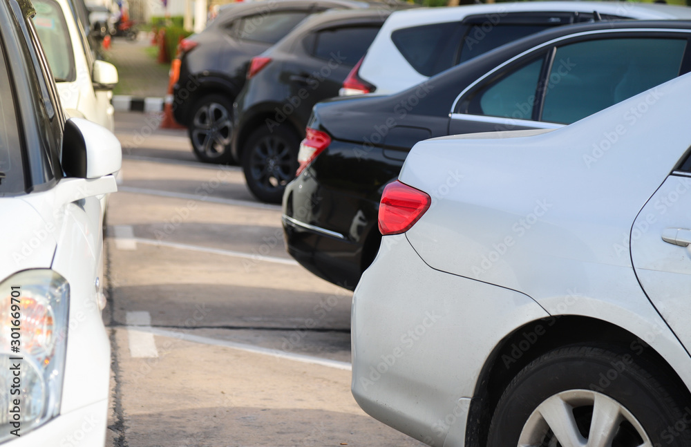 Closeup of rear, back side of soft blue car with  other cars parking in outdoor parking area in sunny day. 