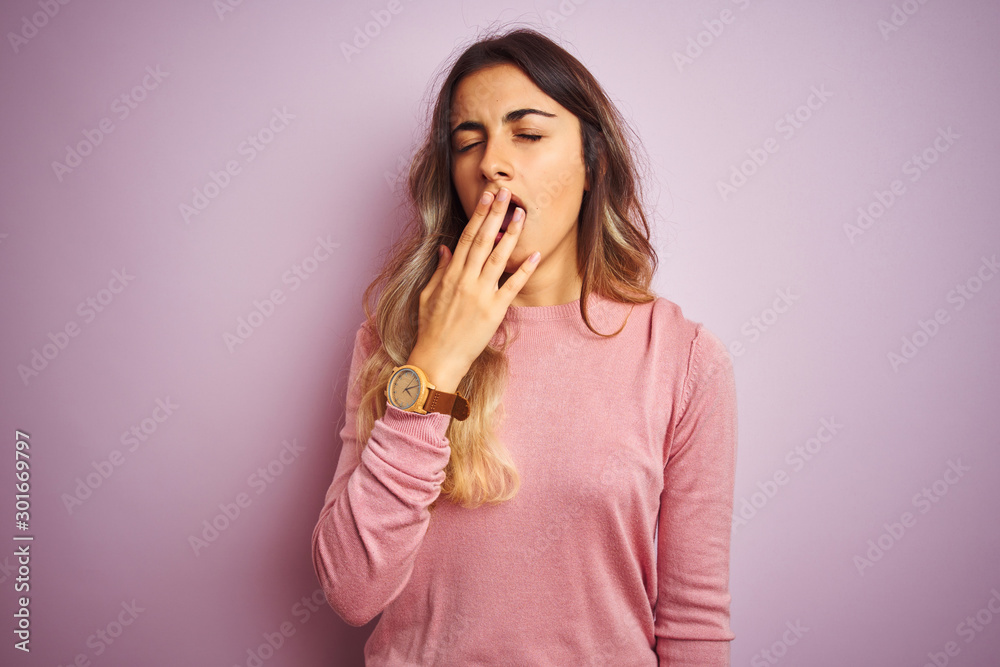 Young beautiful woman wearing a sweater over pink isolated background bored yawning tired covering mouth with hand. Restless and sleepiness. Young beautiful woman wearing a sweater over pink isolated background bored yawning tired covering mouth with hand. Restless and sleepiness.