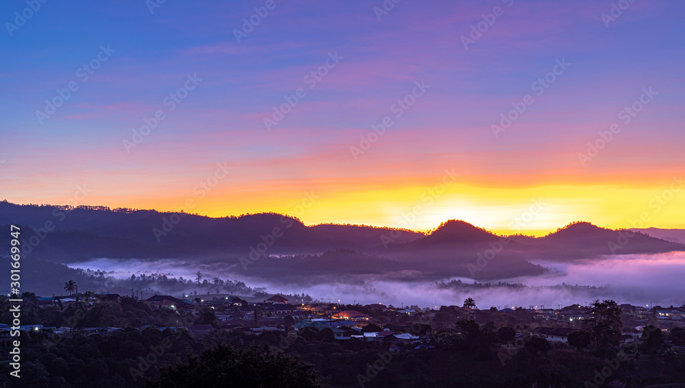 View of village covered in foggy during morning sunrise colorful sky