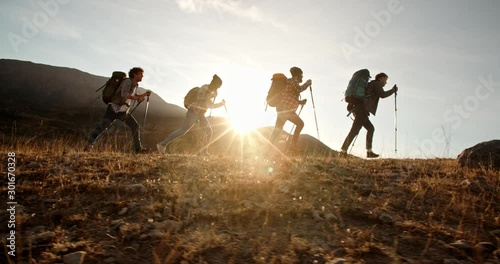 Four young people on hike adventure - Group of students trekking in mountains together, having a vacation - friendship, travel destination concept 4k footage