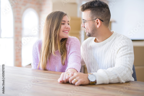 Young cheerful couple smiling happy showing wedding ring, celebrating engagement at home