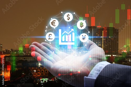 Double exposure of Businessman hand holding interface of Fintech with cityscape and stock market or financial graph for financial investment concept
