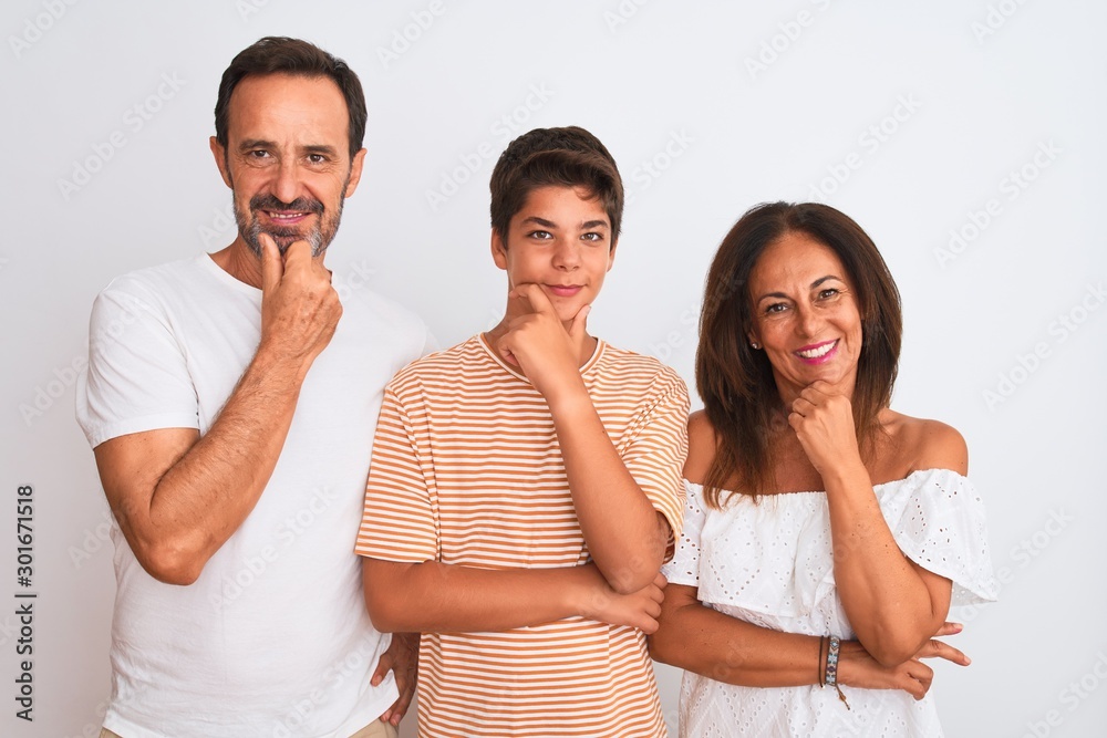 Family of three, mother, father and son standing over white isolated background looking confident at the camera smiling with crossed arms and hand raised on chin. Thinking positive. Family of three, mother, father and son standing over white isolated background looking confident at the camera smiling with crossed arms and hand raised on chin. Thinking positive.