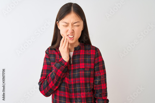 Young chinese woman wearing casual jacket standing over isolated white background touching mouth with hand with painful expression because of toothache or dental illness on teeth. Dentist concept. © Krakenimages.com